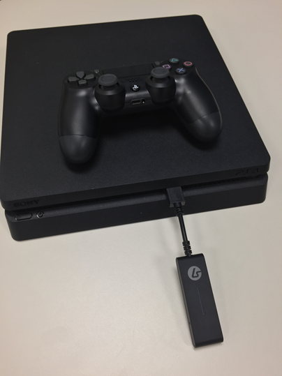 Playstation 4 with a Lucid Sound headphone adapter plugged into the front