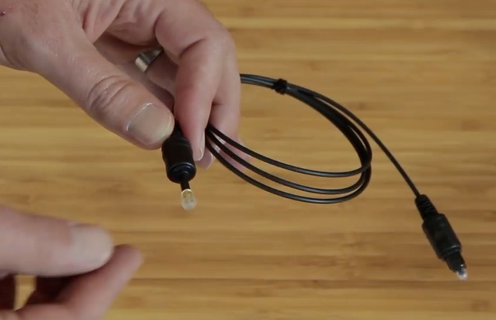 Person removing the end caps from an optical cable