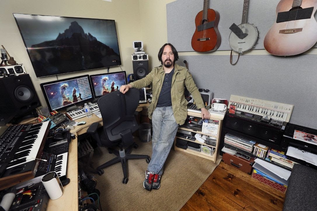 Jim Guthrie in his music studio surrounded by instruments and equipment